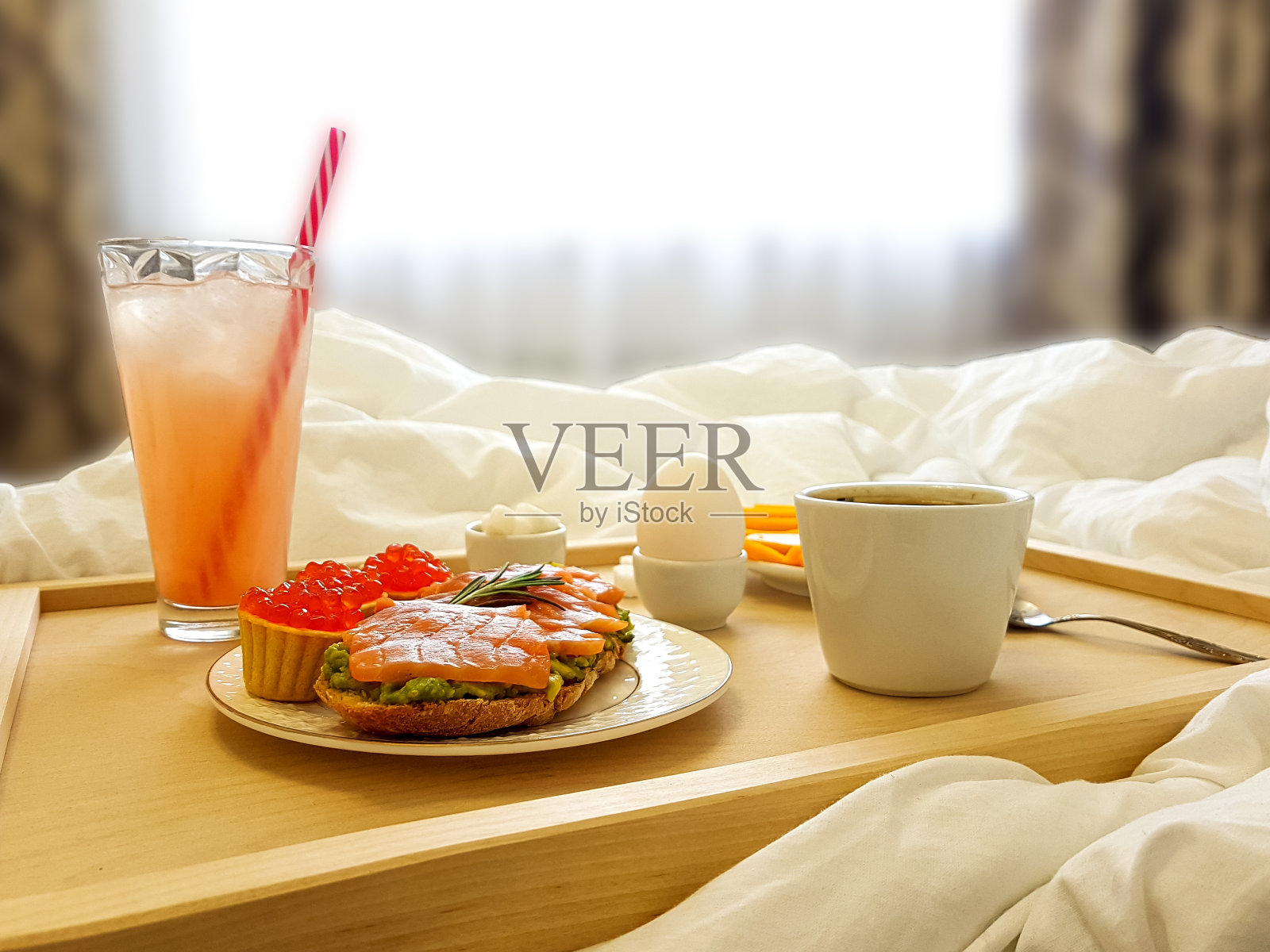 休息日卧室床上的木制早餐桌。照片摄影图片