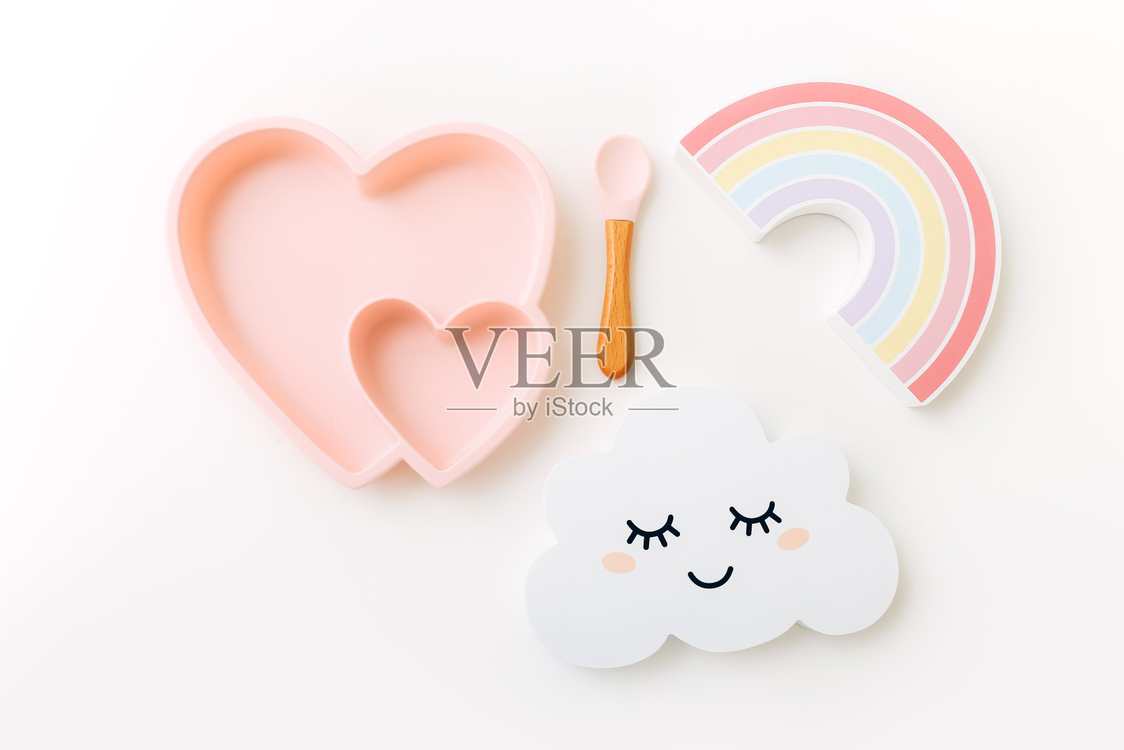 儿童硅胶餐具与木制玩具在光背景，俯视图照片摄影图片