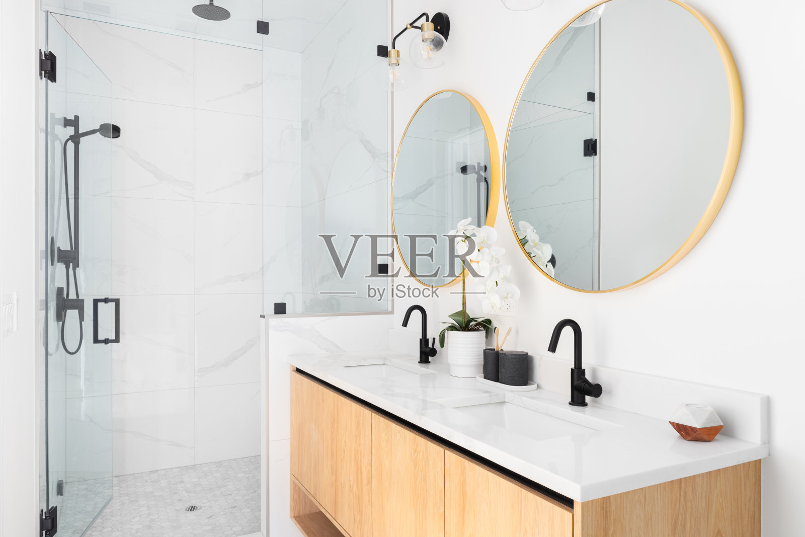 一间漂亮的浴室，有木制浮动柜和大理石步入式淋浴间。照片摄影图片