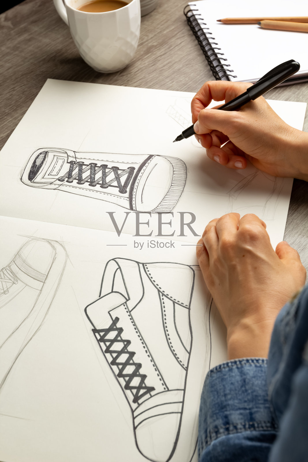 艺术家设计师在纸上画了一张鞋子的草图。照片摄影图片