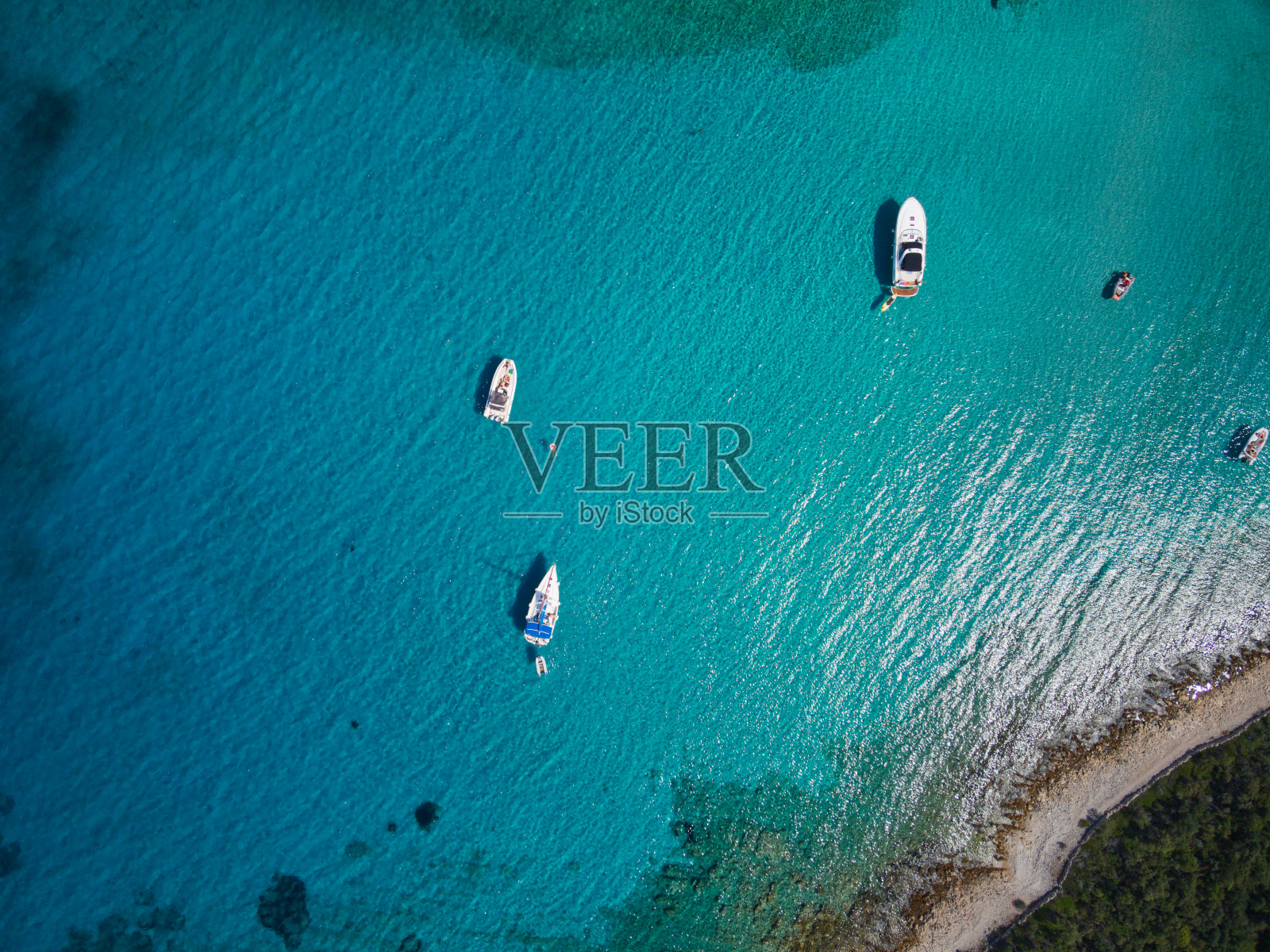 无人机的游艇和帆船锚定在一个蓝色的泻湖与水晶般清澈的水照片摄影图片