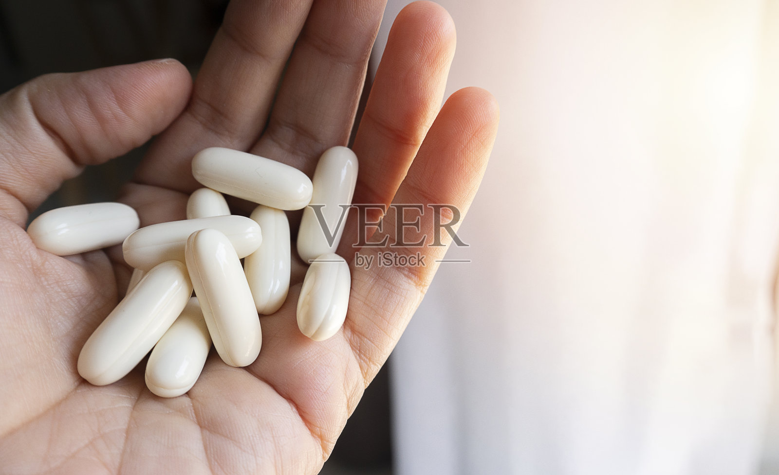 年轻女子手握药材胶囊照片摄影图片