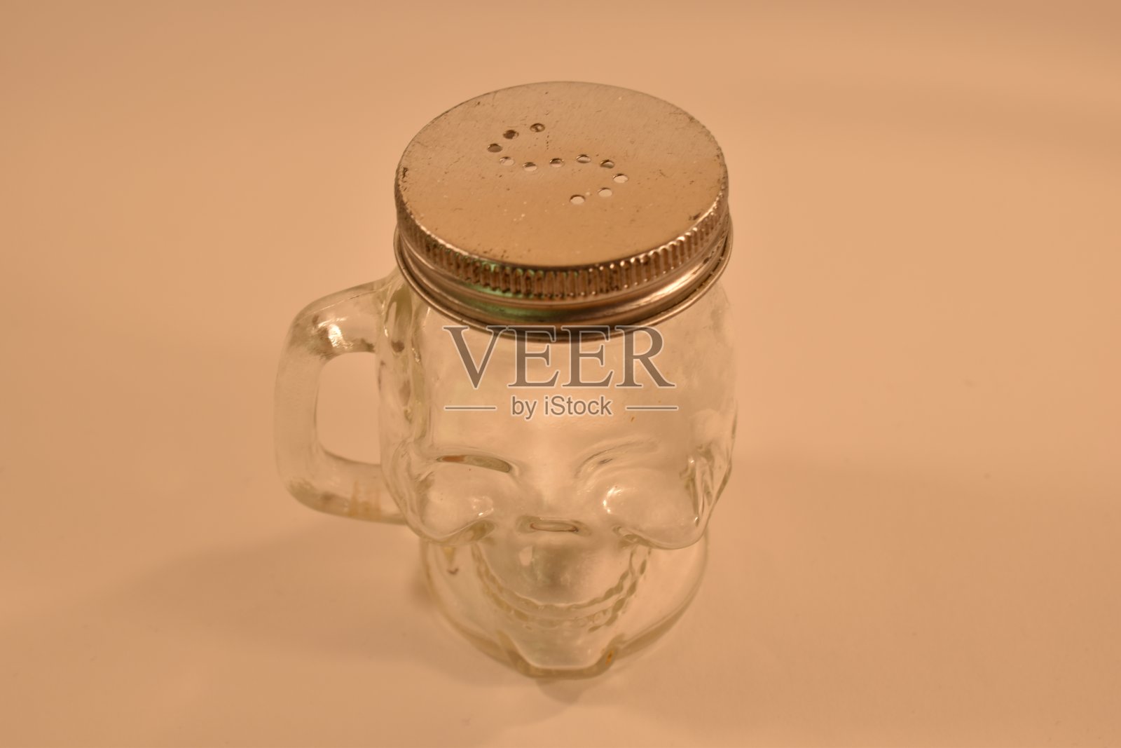 白色背景上有一罐头骨形状的盐照片摄影图片