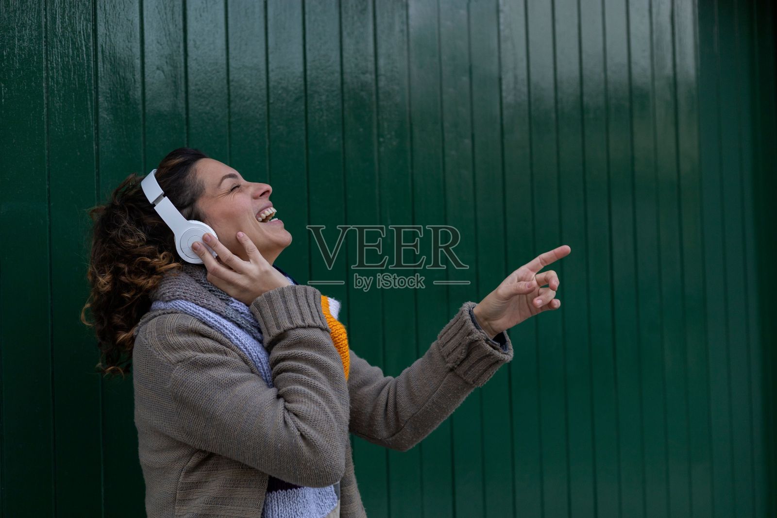 年轻的拉丁美洲女孩戴着耳机听音乐照片摄影图片