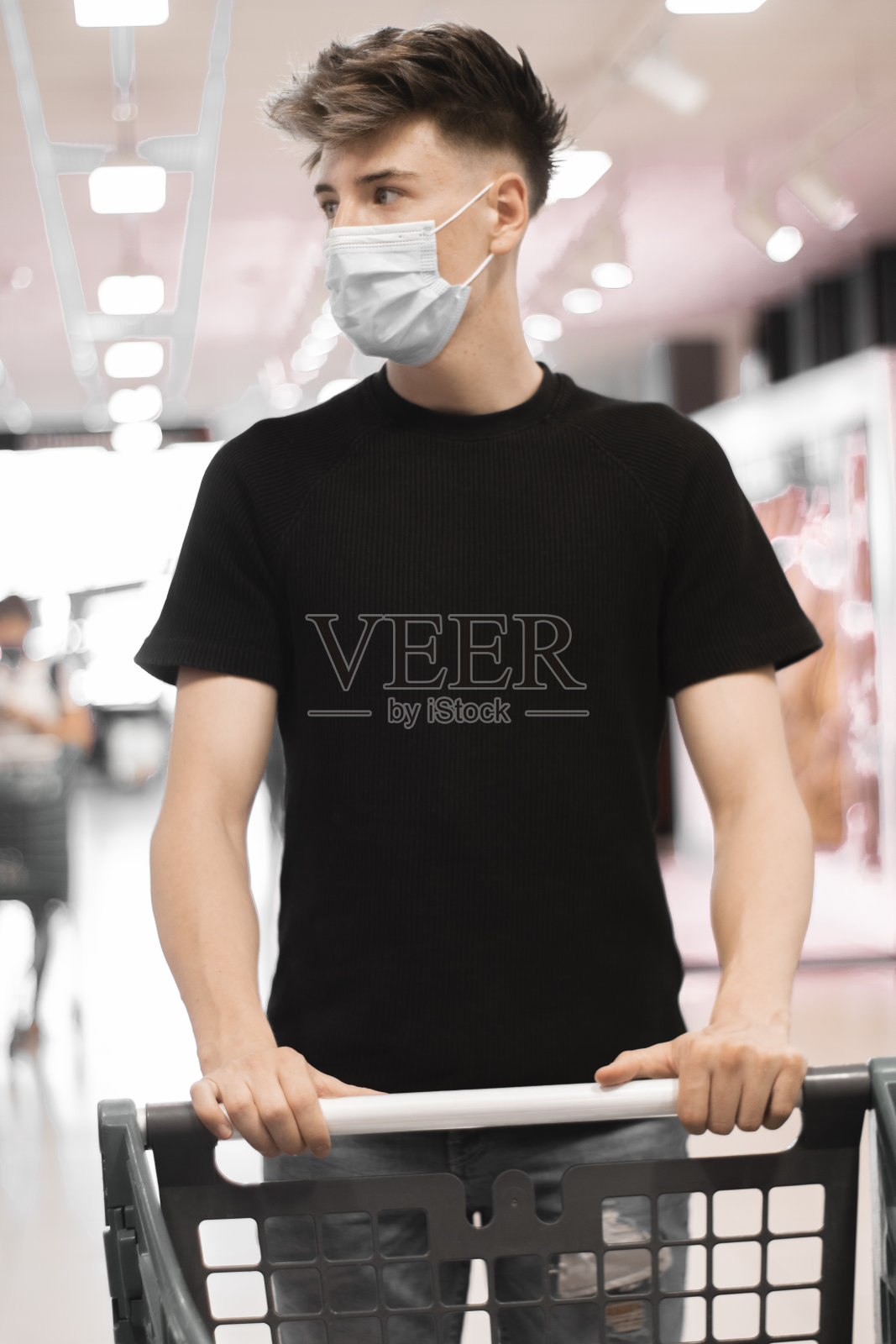 垂直拍摄一个戴着医用口罩的白人男孩在买杂货照片摄影图片