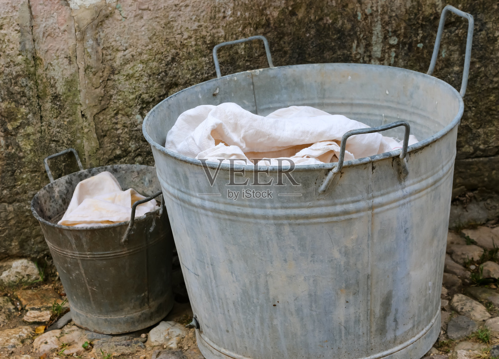 洗衣服用的浴缸和装干净床单的小桶照片摄影图片