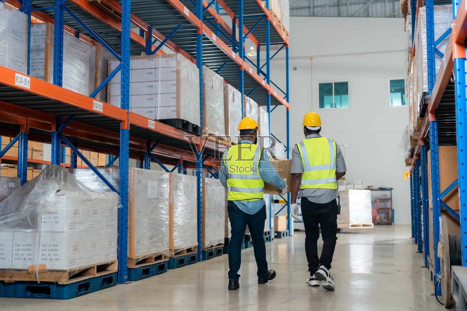 两个非洲工人在仓库工作时交谈。照片摄影图片