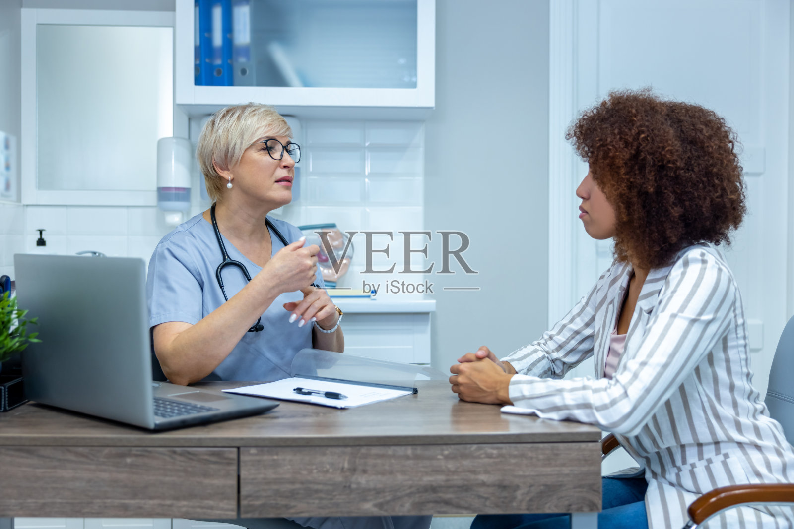 一个卷头发的年轻女人正在和医生约会照片摄影图片