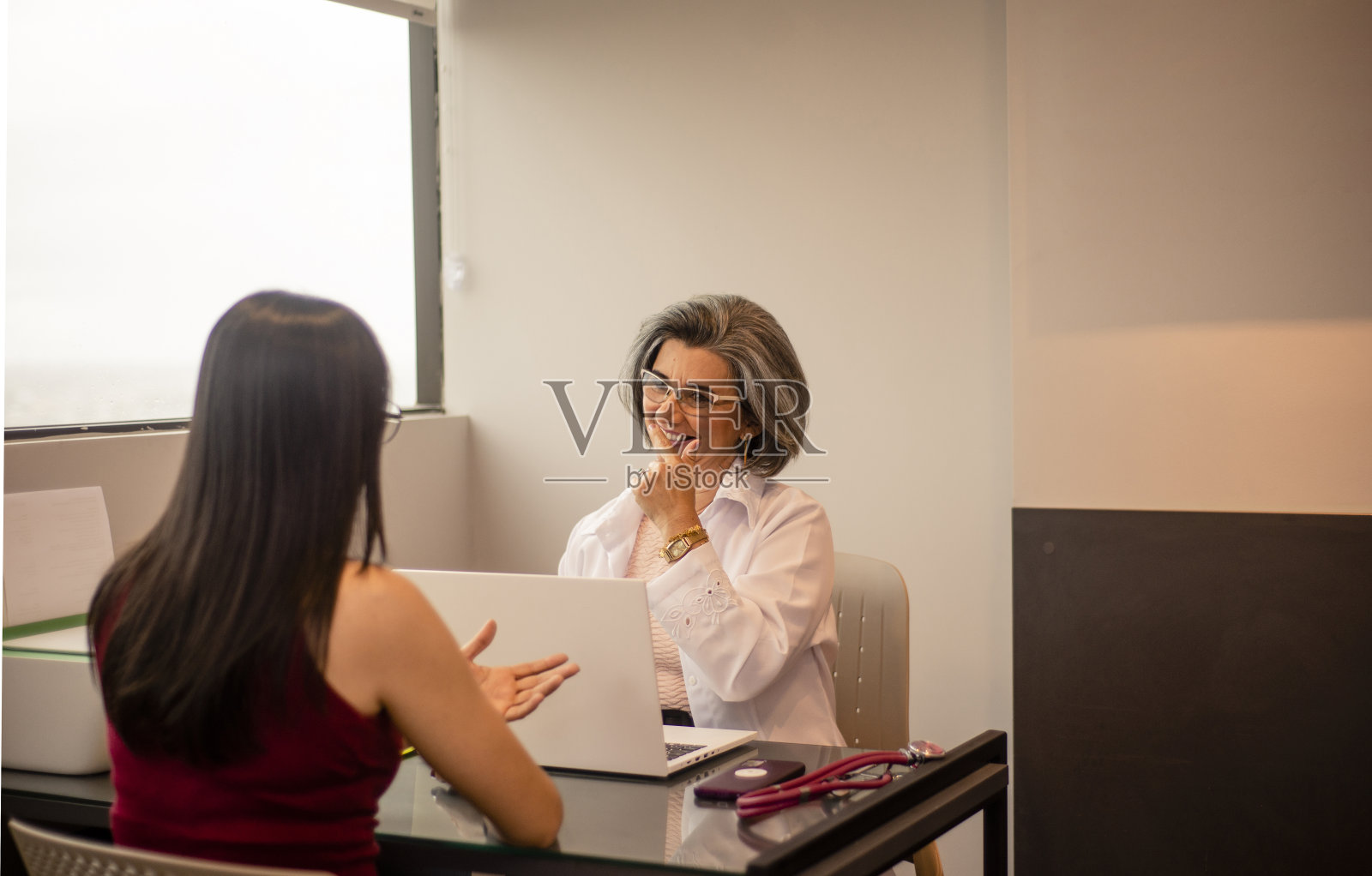 医生在她的办公室提供治疗。照片摄影图片