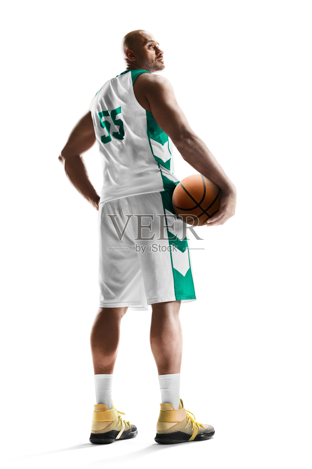 篮球。职业篮球运动员手里拿着球站着。在白色的背景上。后视图。运动。孤立的照片摄影图片