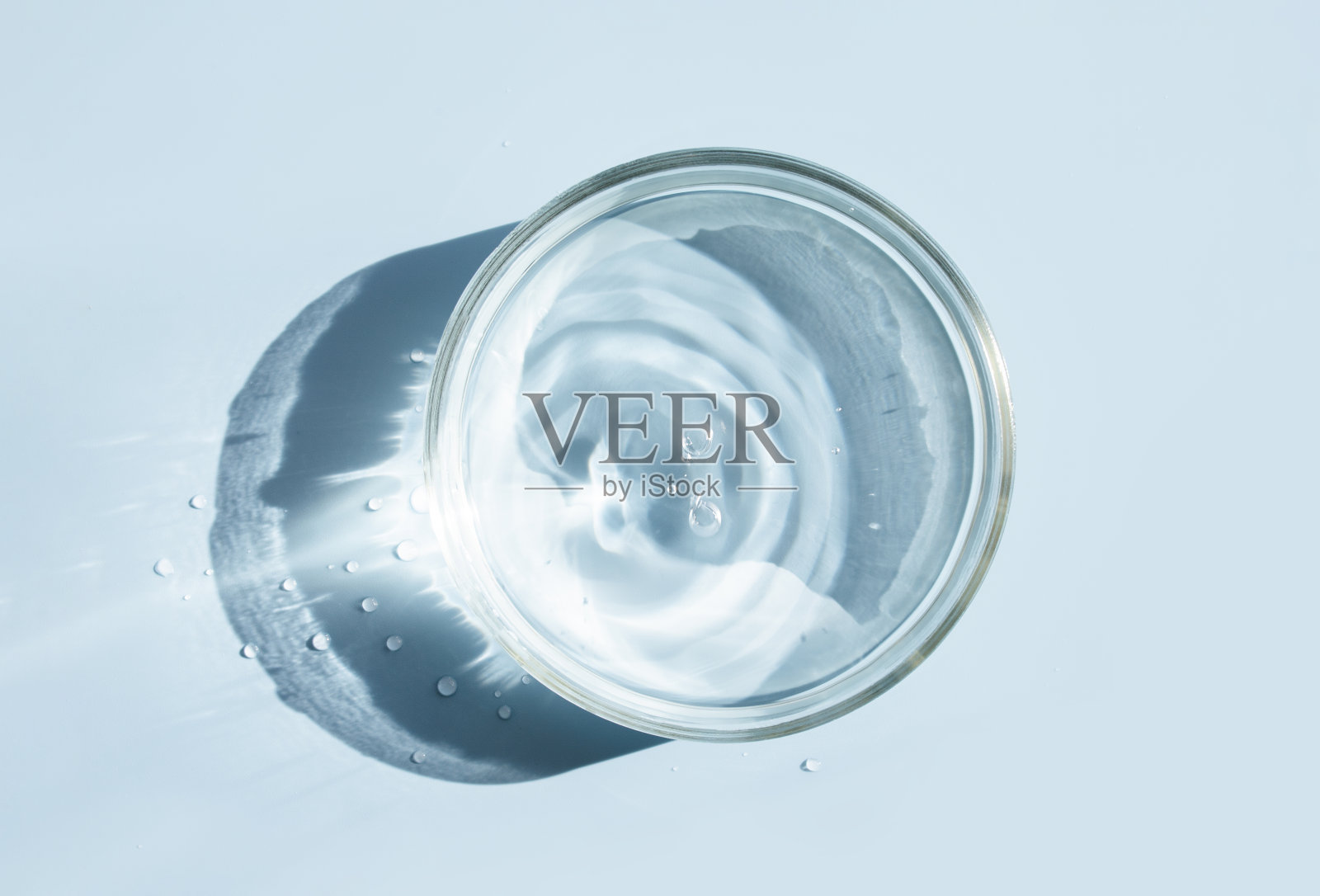 培养皿上有液态水，底色淡上有水纹纹理照片摄影图片