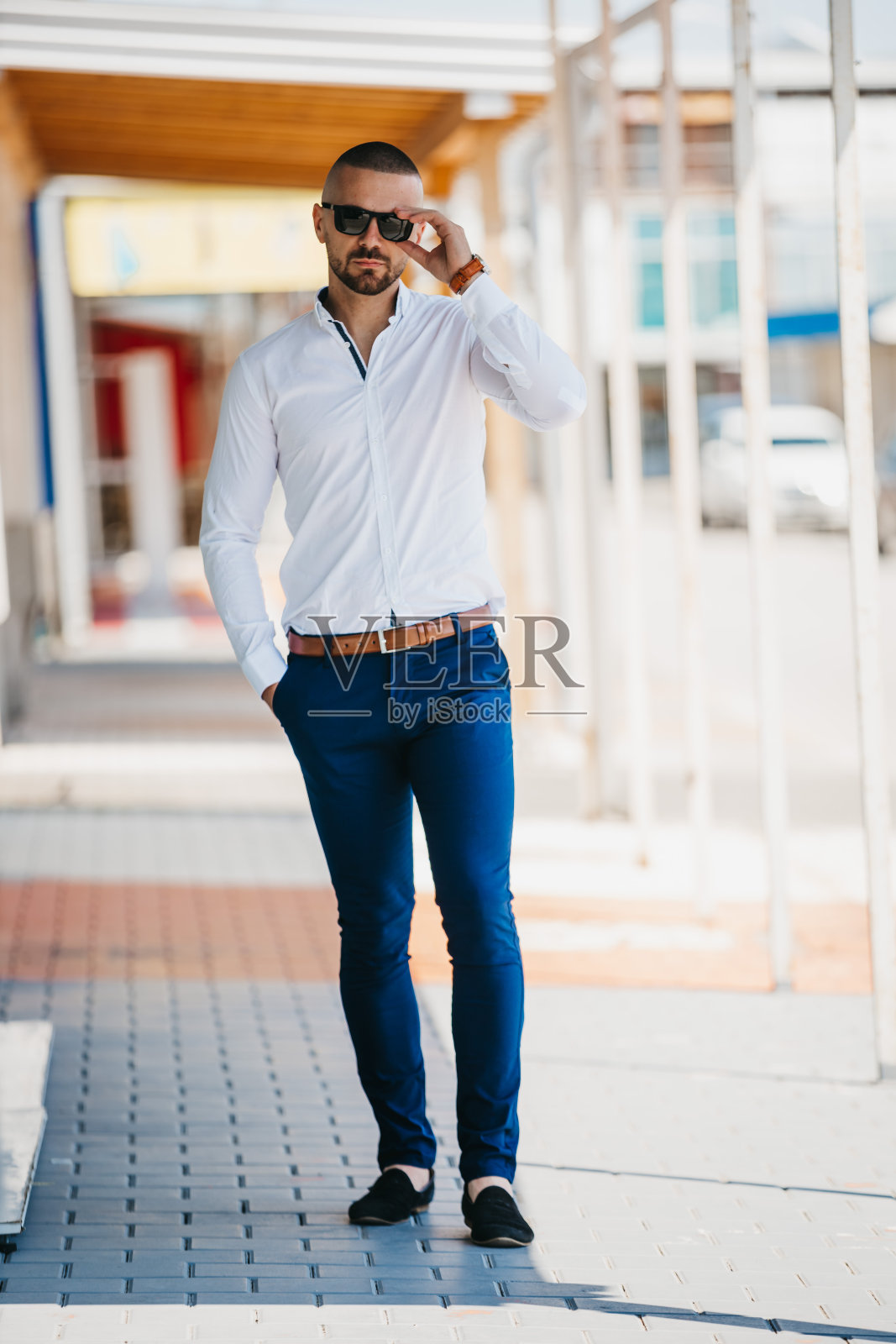 一个身穿白衬衫、戴着墨镜的年轻人的垂直镜头照片摄影图片