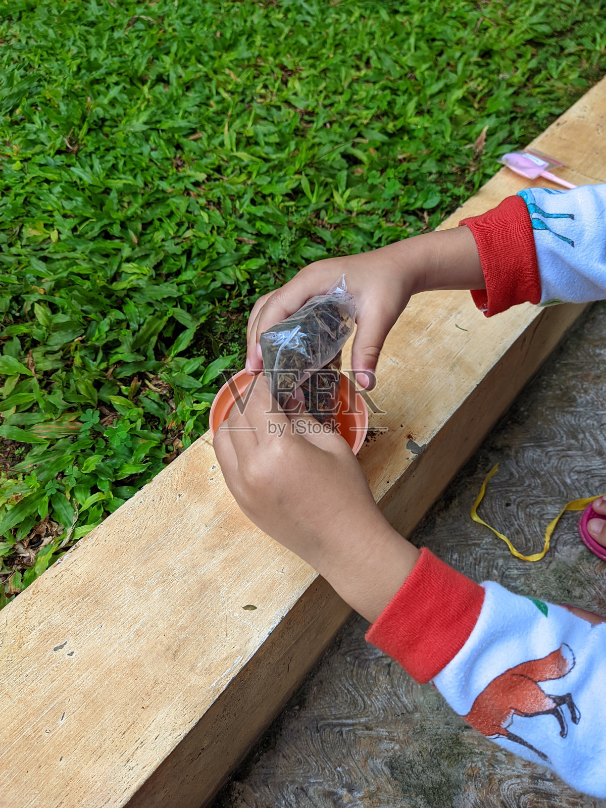 一个孩子把种植介质移到花盆里照片摄影图片
