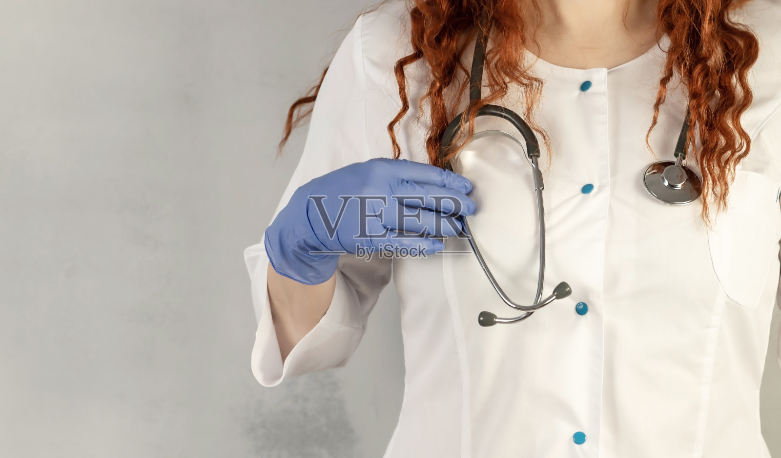 一名穿着医用白大褂的医生手里拿着听诊器。医学概念。照片摄影图片