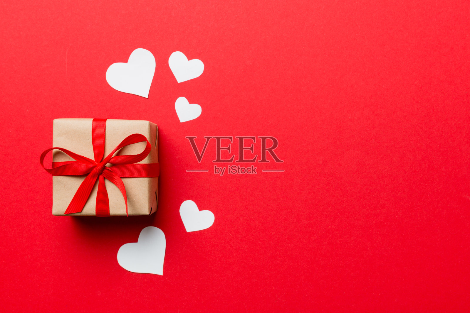 情人节作文:红色礼盒上有蝴蝶结和爱心。圣诞礼物。从上面看。文本空格。节日贺卡照片摄影图片