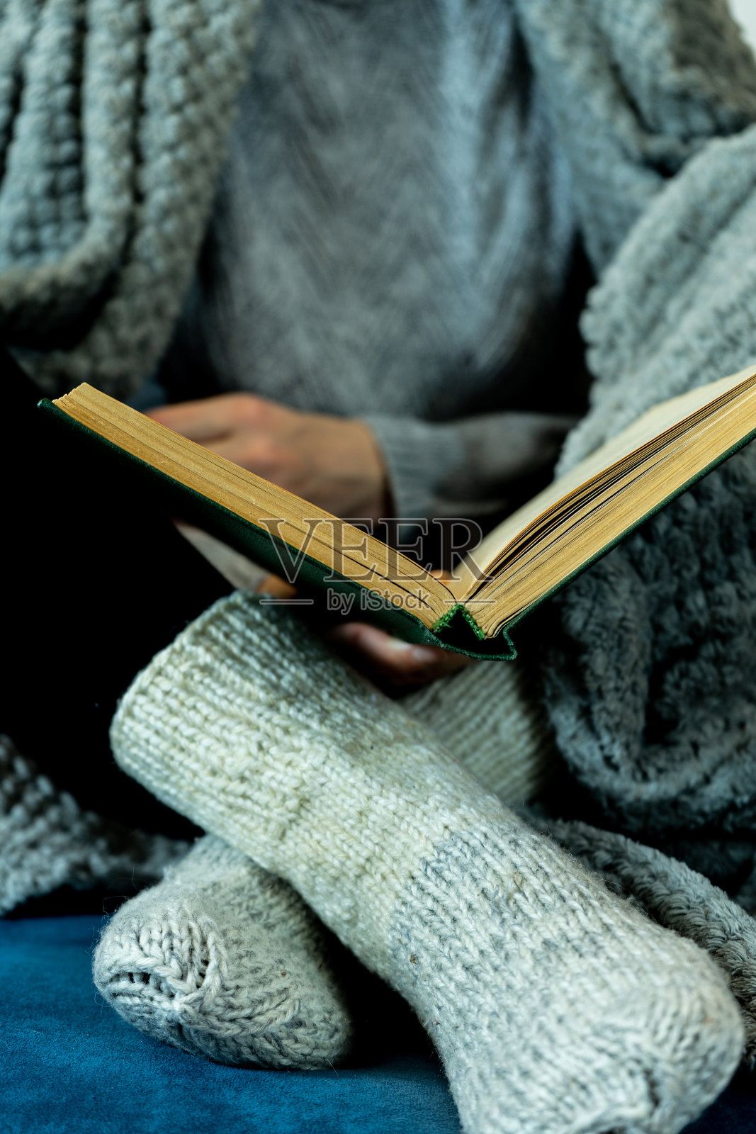 这个女孩盘腿坐着，呈莲花式，正在看书。一个女人手里拿着一本教科书。教育理念，发展自强。有选择性的重点。照片摄影图片