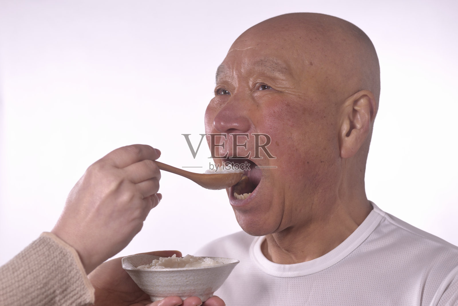 用护理的方式喂老人粥照片摄影图片