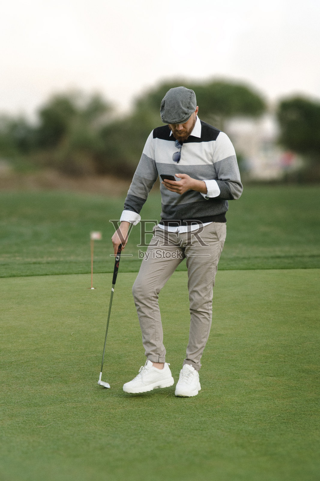 一个高尔夫球手在高尔夫球场上使用手机的肖像照片摄影图片