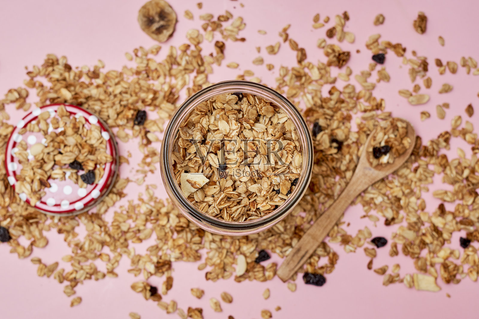 一罐格兰诺拉麦片，旁边放着一个木勺照片摄影图片