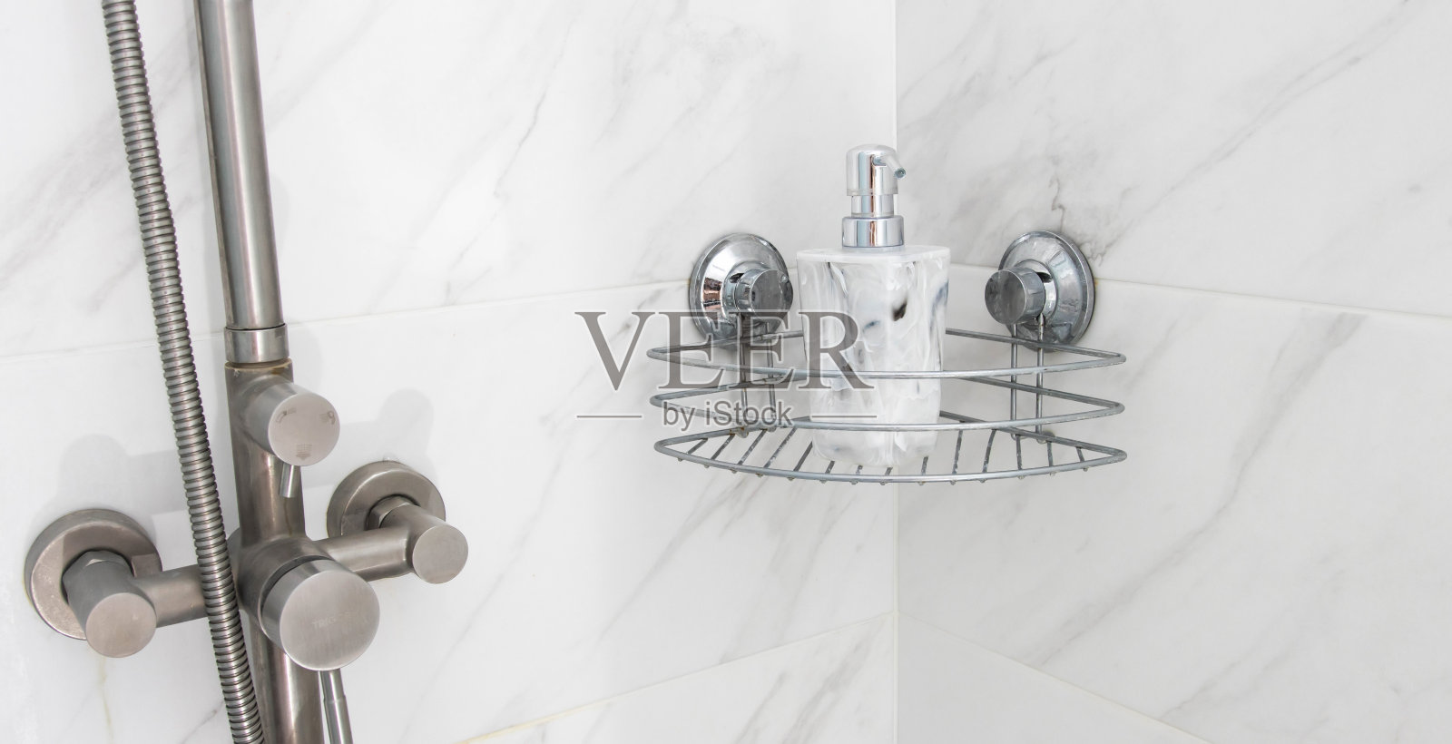 浴室里有一个镀铬的架子，还有一个大理石瓶的液体肥皂。照片摄影图片