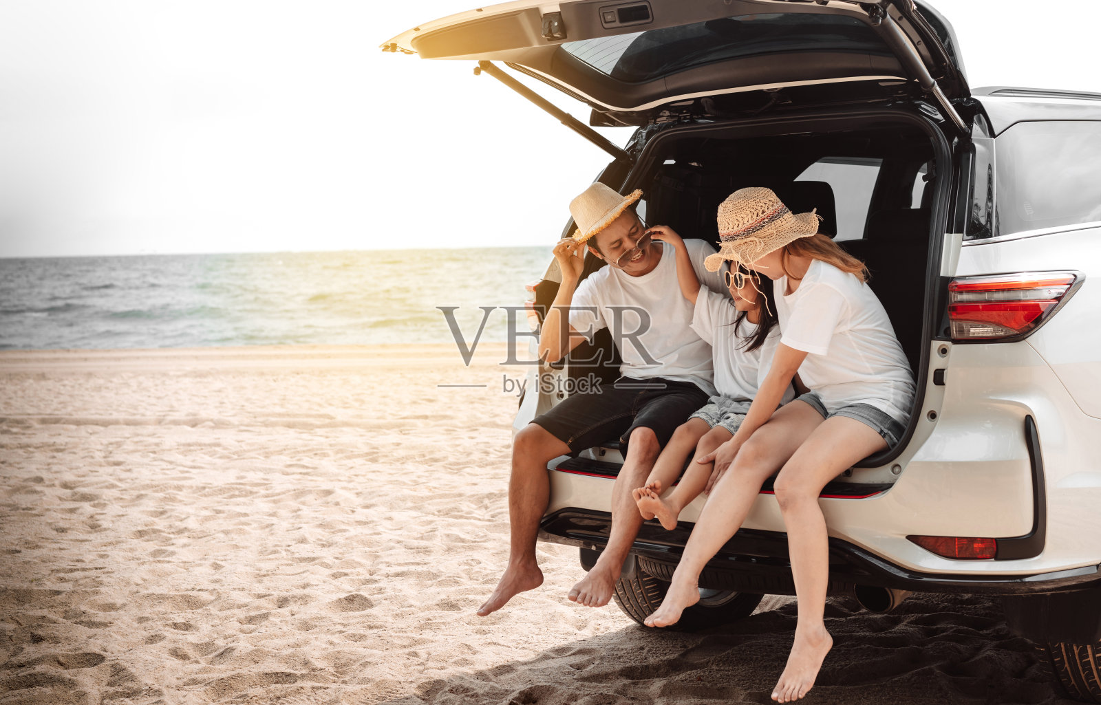 一家人带着自驾游自驾游暑假，在夕阳下的汽车里，爸爸、妈妈和女儿一起快乐的旅行享受假期和放松的氛围，一起去目的地照片摄影图片