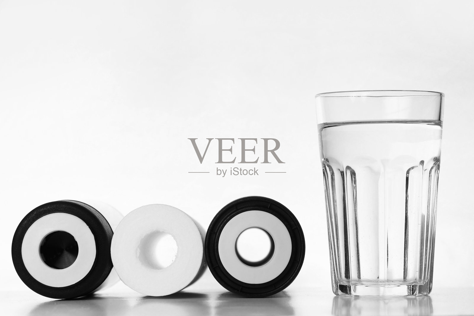 旗帜的三个墨盒的水过滤器与清澈的新鲜玻璃水隔离在白色背景。安装RO、反渗透净水系统。家用过滤系统。照片摄影图片