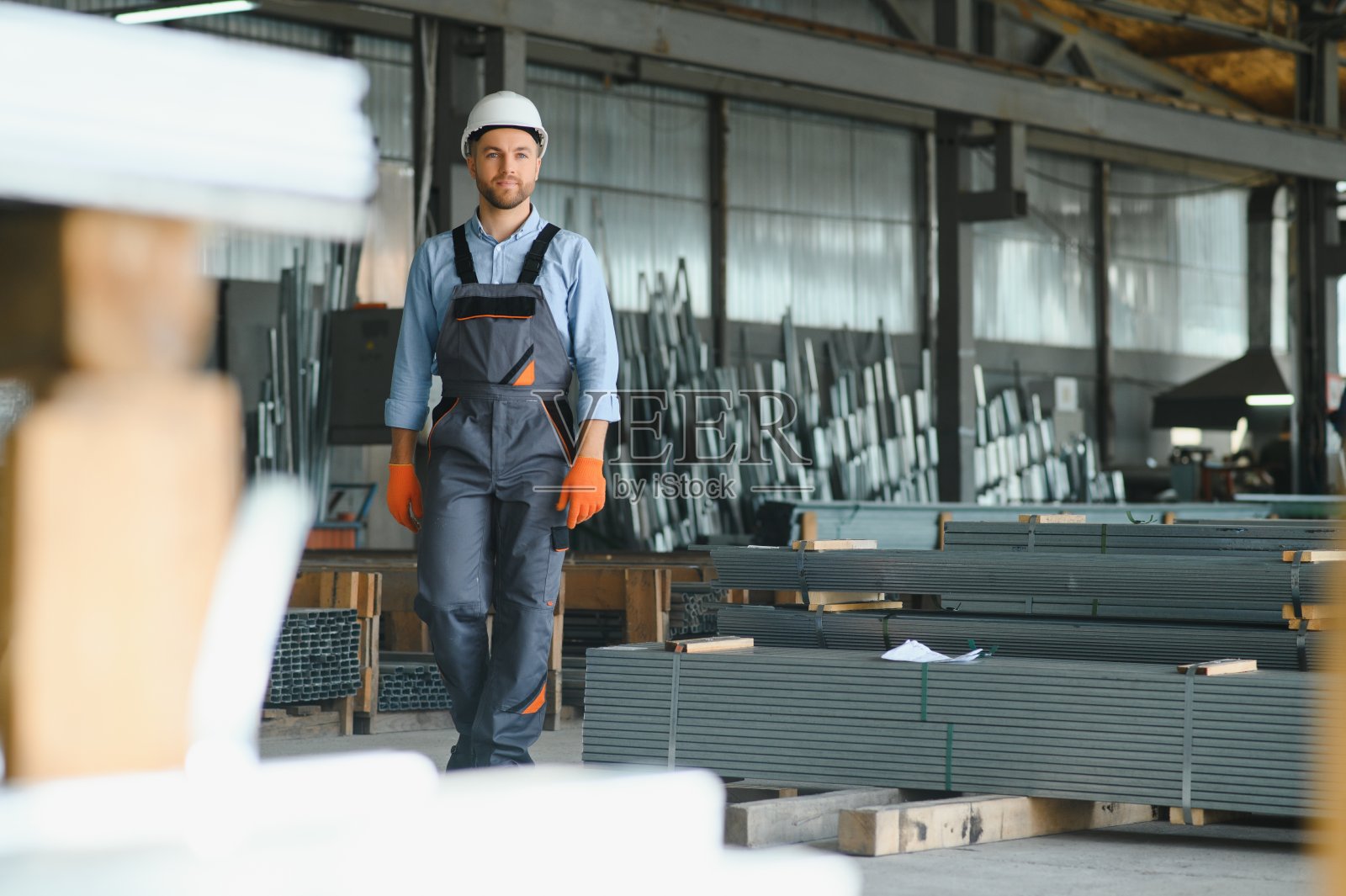 专业的面料工人。金属加工厂。金属型材仓库的工人。照片摄影图片