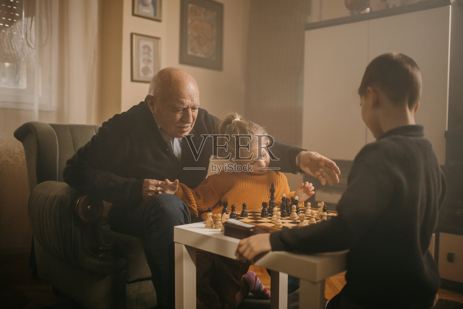 孩子们和爷爷下棋照片摄影图片