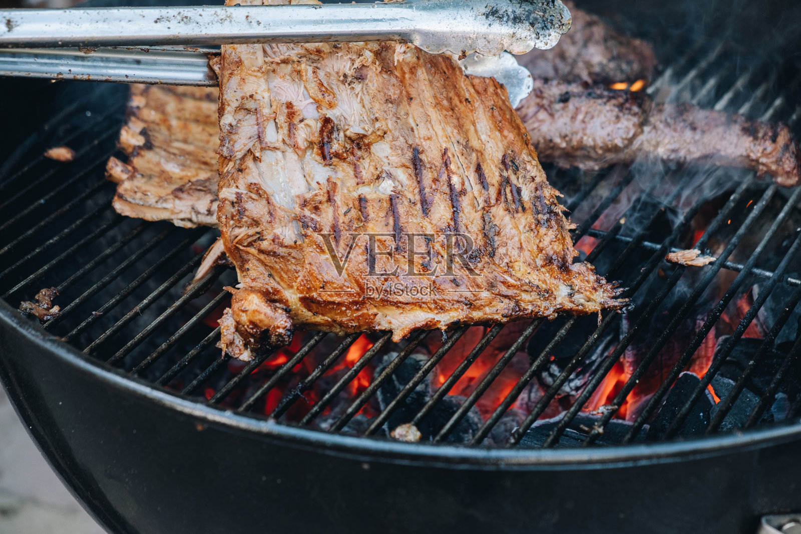 把排骨放在烤架上烤。烟熏烤排骨。照片摄影图片