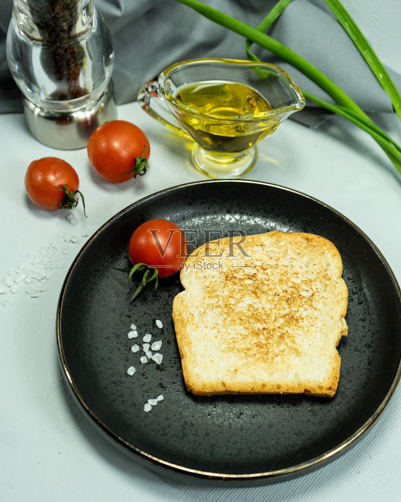 面包片，三明治，红番茄，盐瓶，绿色蔬菜。用有机农产品做早餐或零食的概念。三明治配新鲜西红柿。有选择性的重点。照片摄影图片