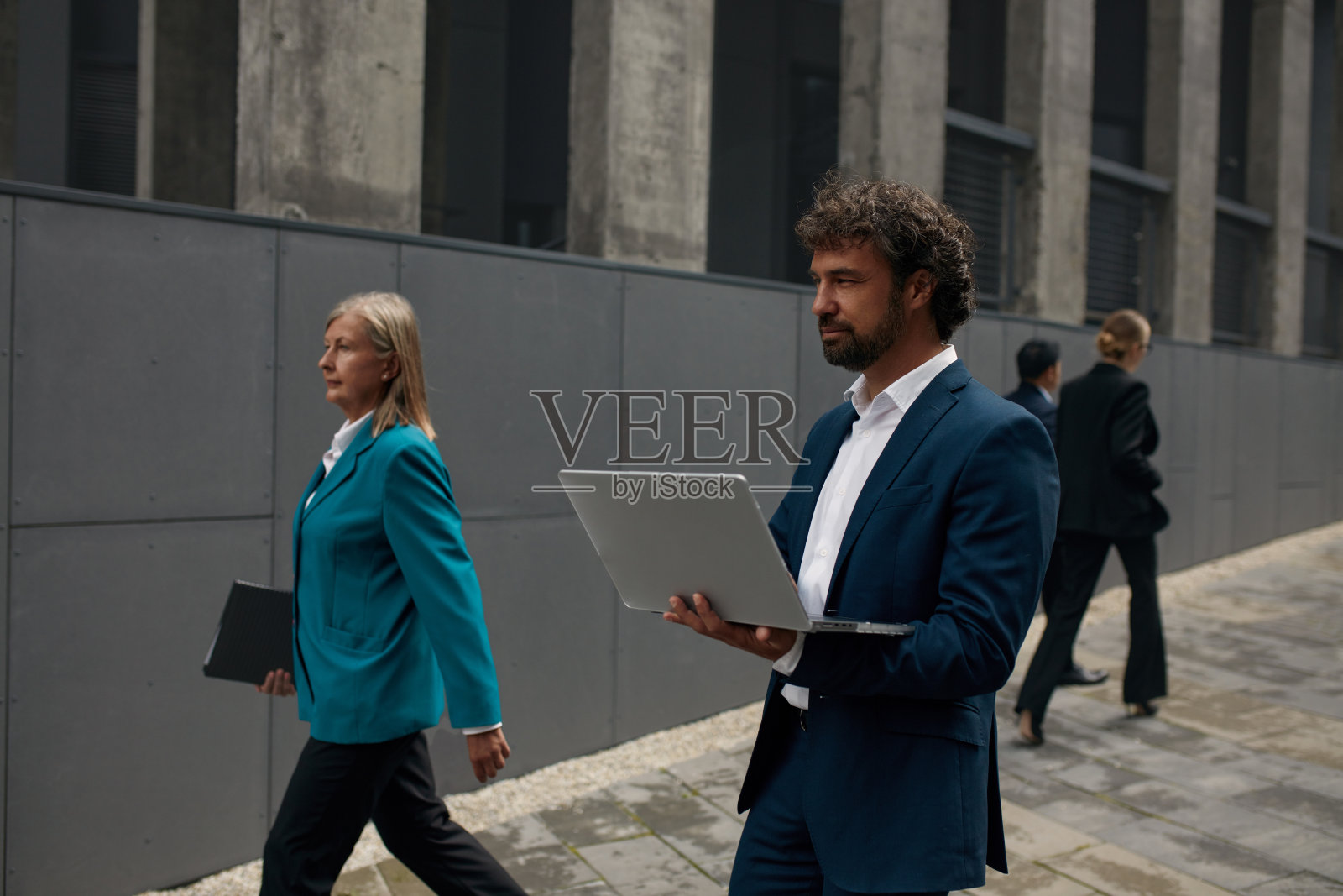 忙碌的男女同事早晨走在街上照片摄影图片