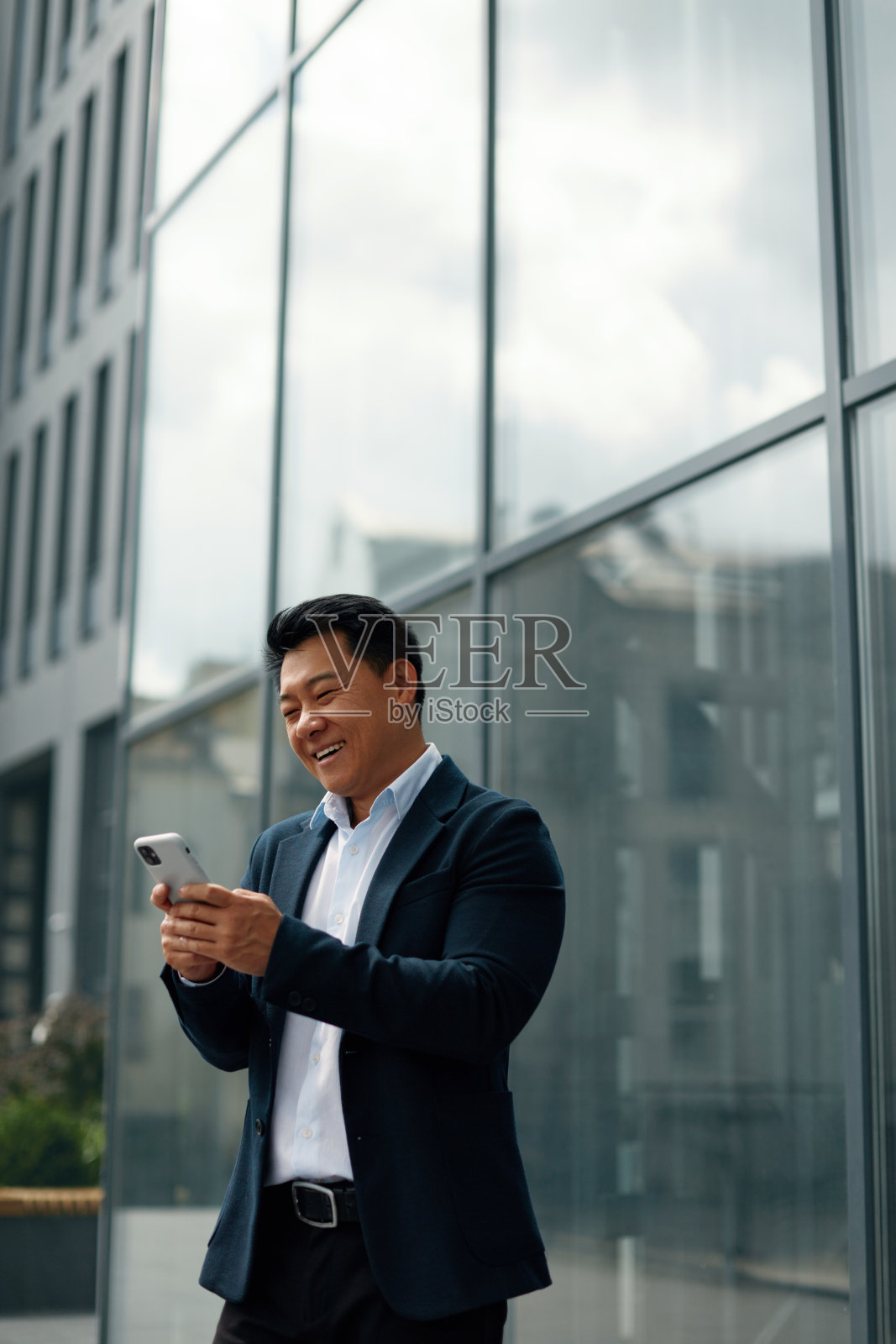 亚洲商人在休息时在办公室附近打电话照片摄影图片