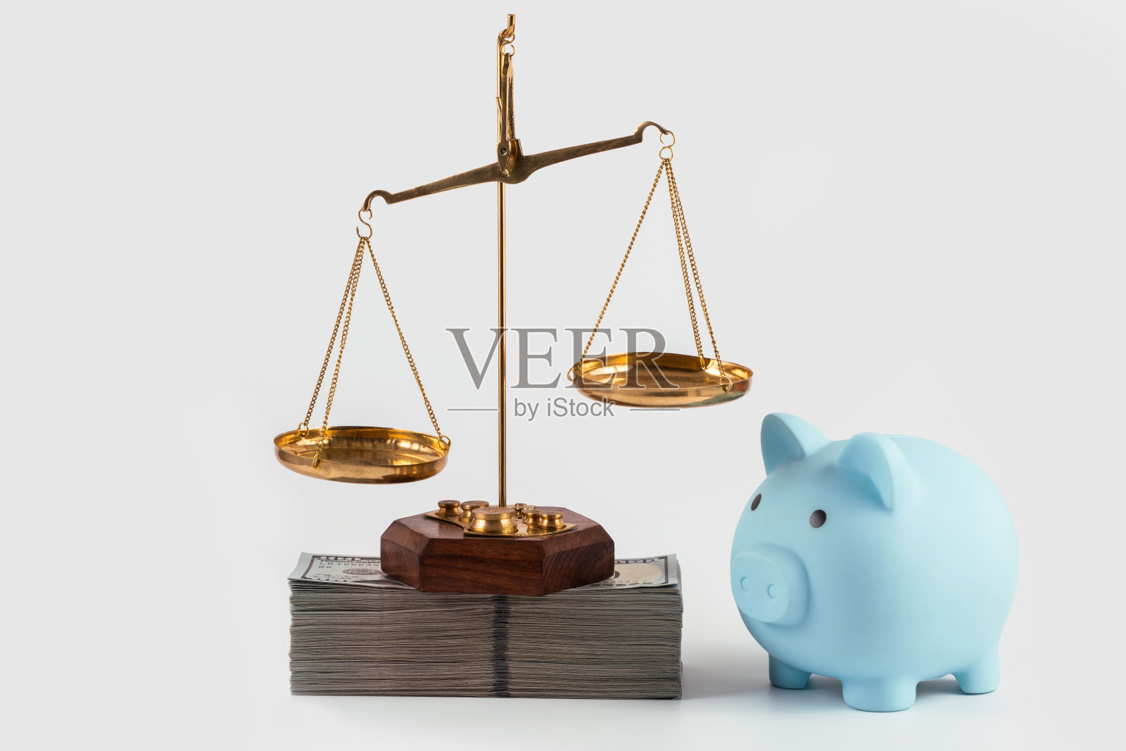 金色的天平和灰色背景上的一大堆100美元钞票照片摄影图片