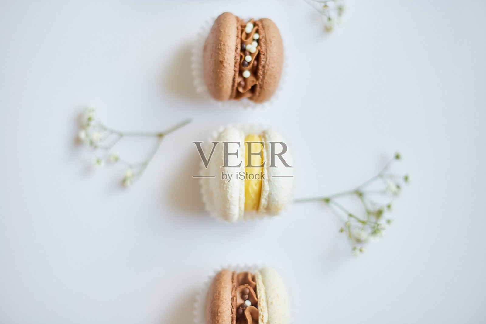 顶部视图集不同的法国饼干马卡龙，蛋糕马卡龙花在白色背景，丰富多彩的杏仁饼干，柔和的颜色照片摄影图片