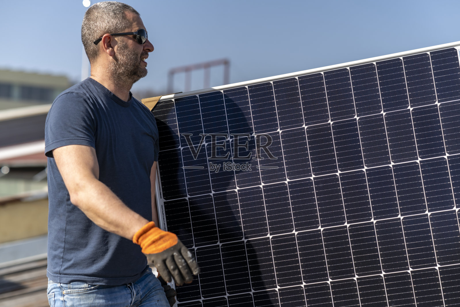 两名工程师在屋顶安装太阳能电池板。照片摄影图片