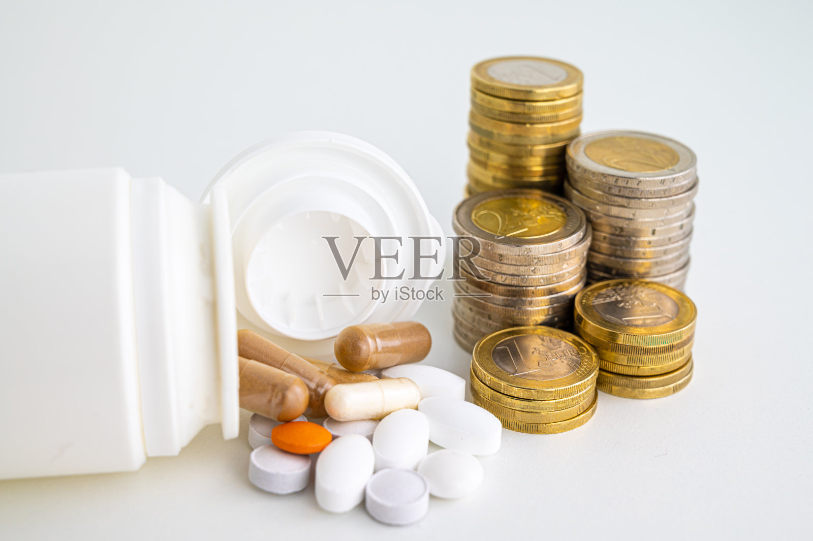药品，旁边有一堆硬币。药品成本。照片摄影图片