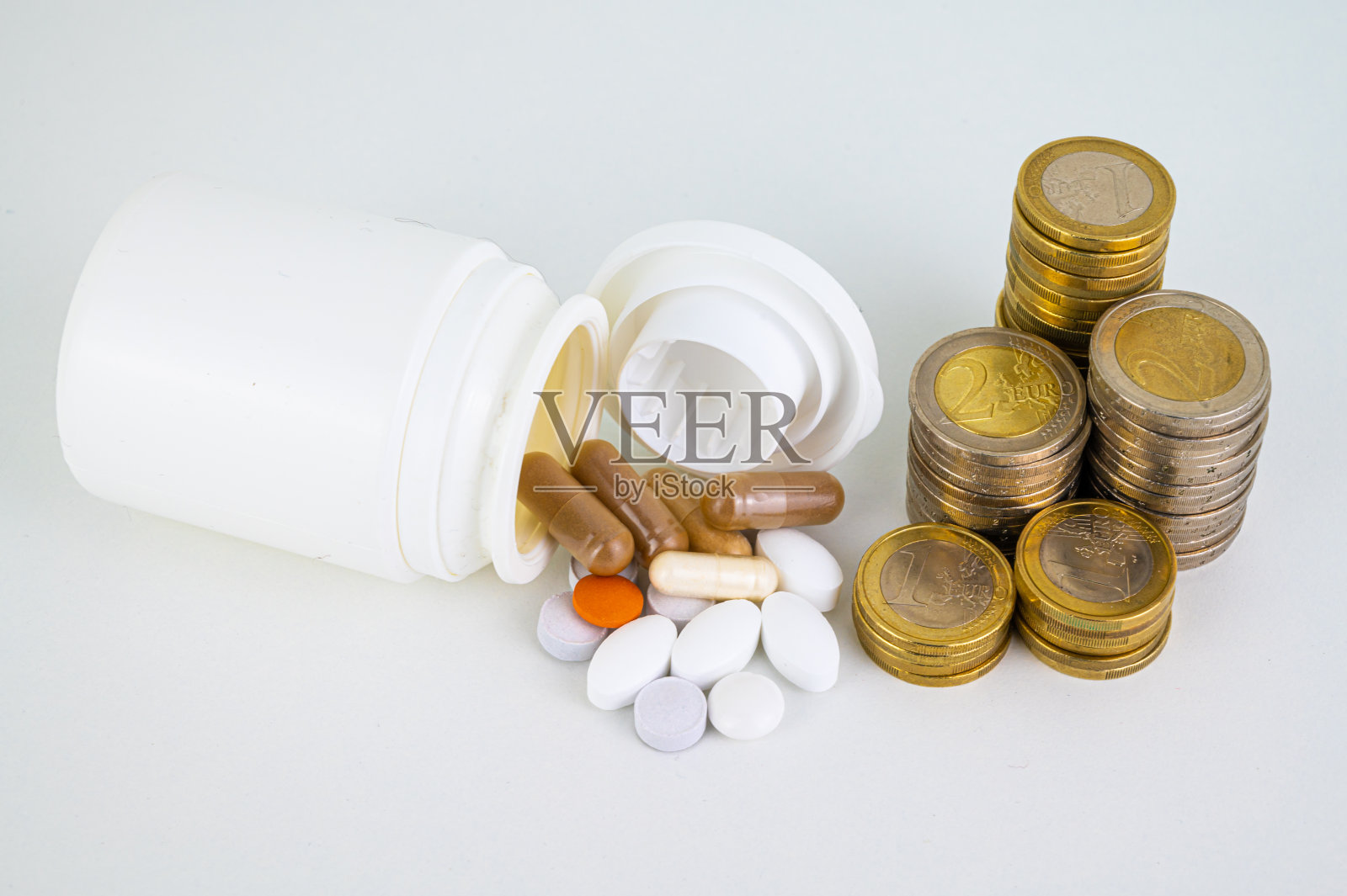 药品，旁边有一堆硬币。药品成本。照片摄影图片