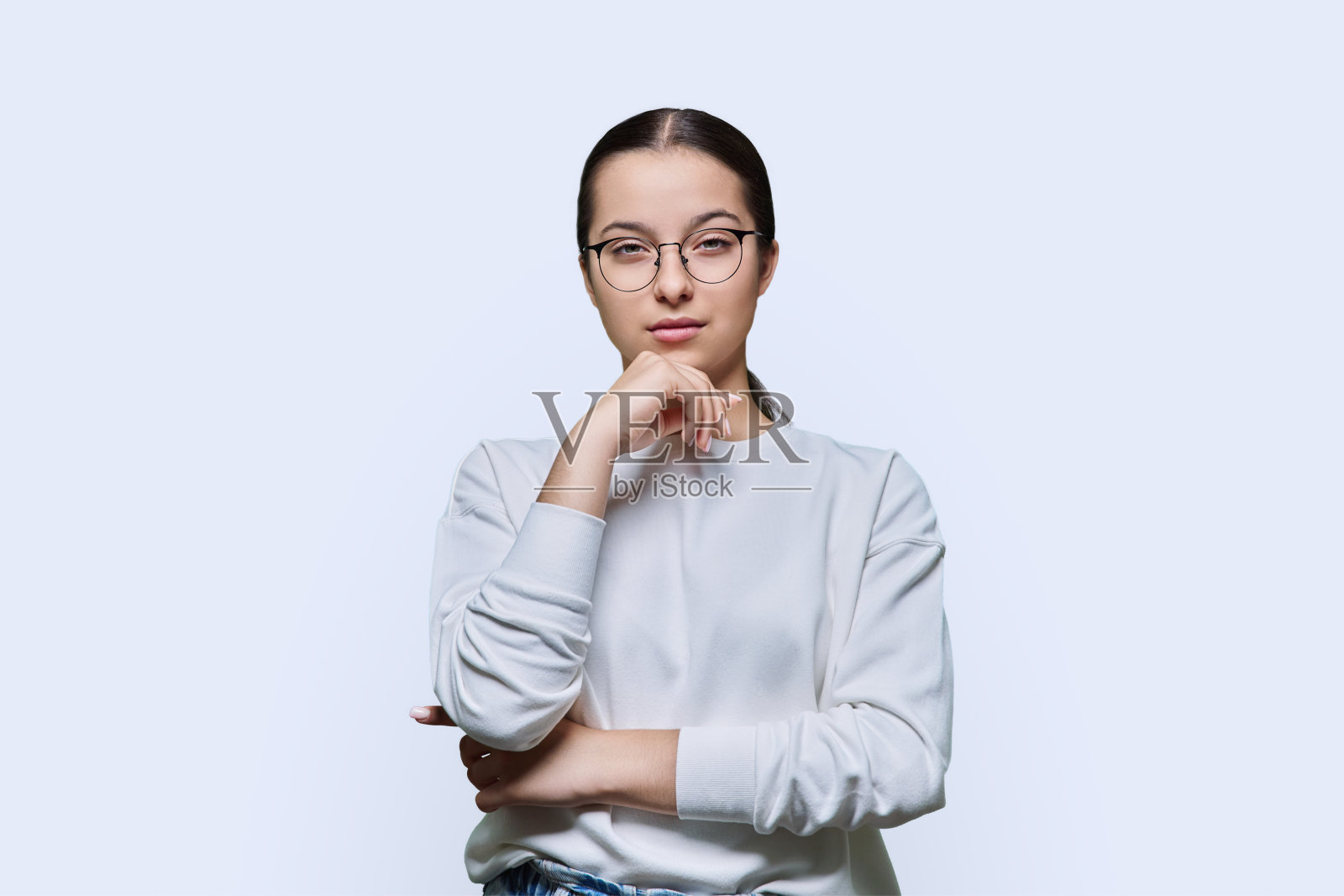 十几岁的女孩在眼镜看着相机在白色的工作室背景照片摄影图片