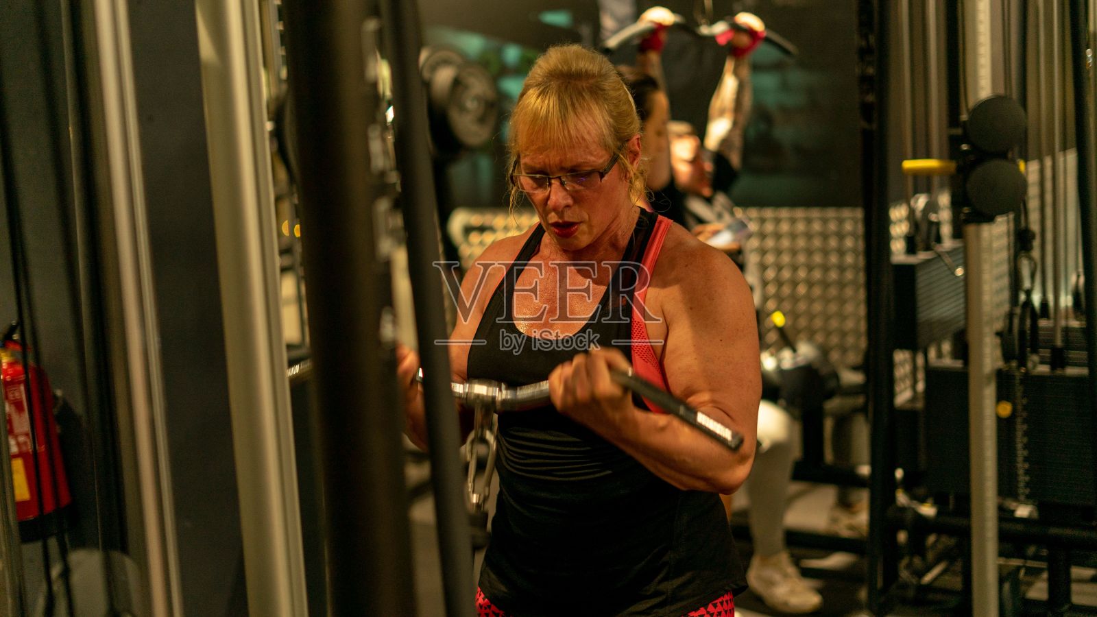 白人肌肉女在健身房训练。照片摄影图片