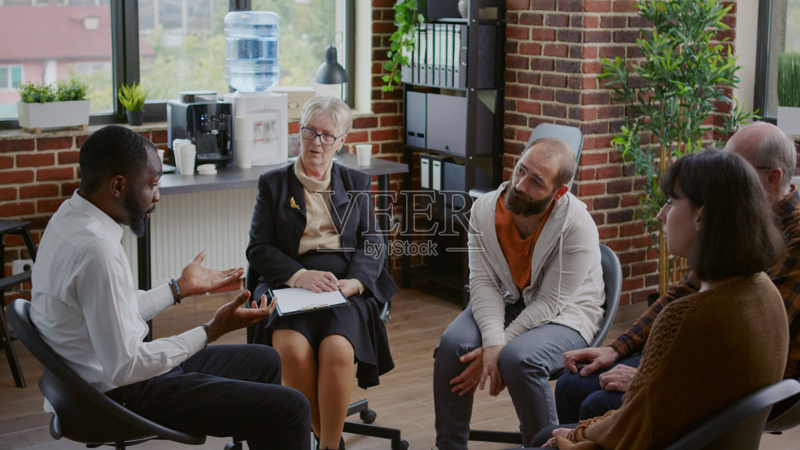 多民族的人正在讨论成瘾在一个团体治疗照片摄影图片