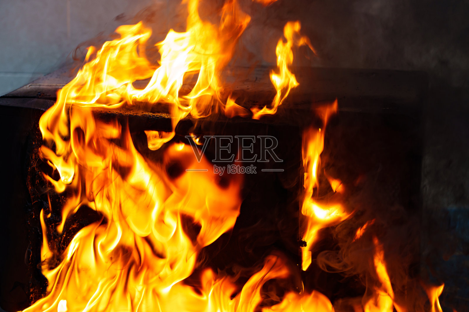 黑色背景上的火焰和熔融塑料。厨房火的概念。照片摄影图片