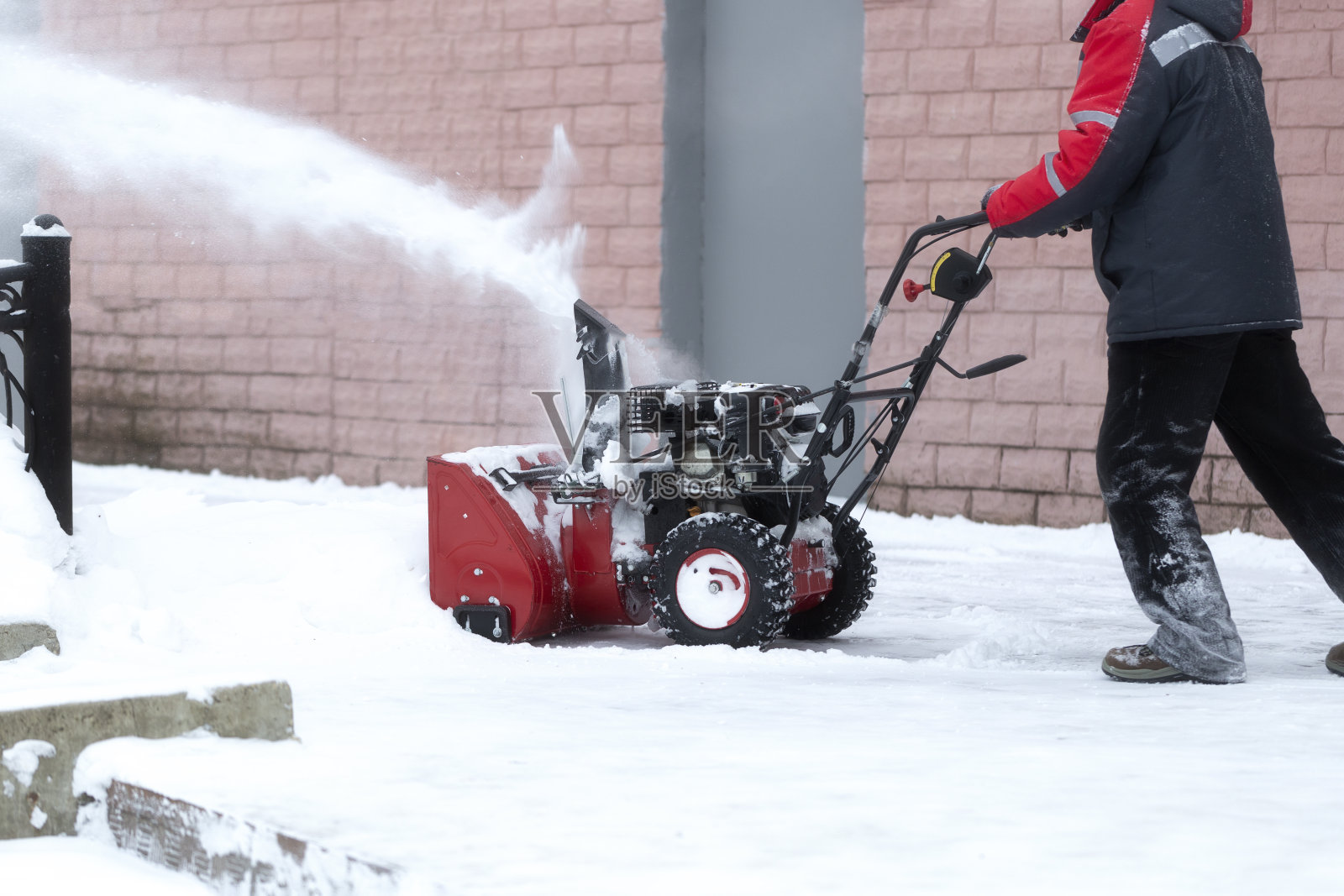 用汽油驱动的便携式吹雪机。照片摄影图片