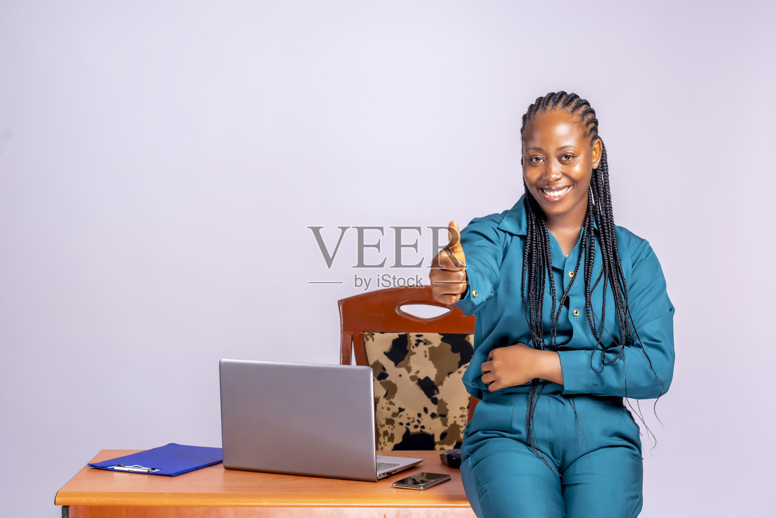 一个美丽的非洲妇女站在办公室的工作场所竖起大拇指的肖像照片摄影图片