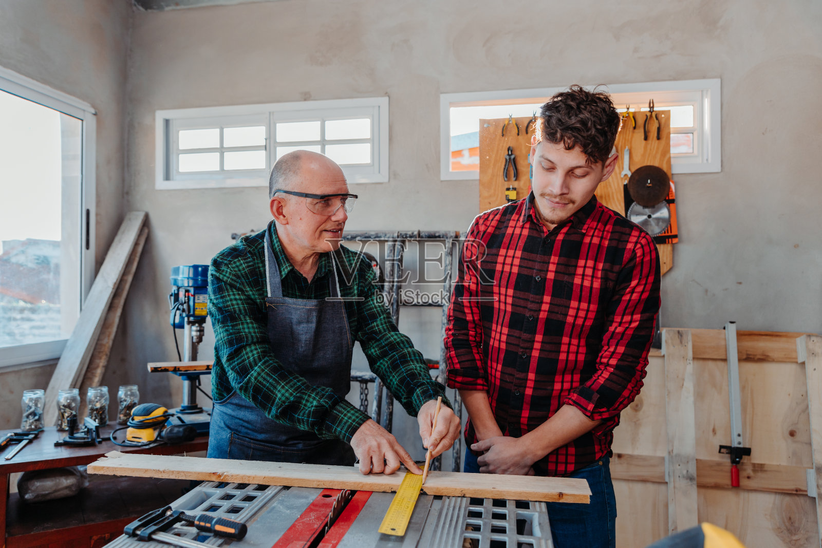 老木匠教一个年轻人如何工作照片摄影图片