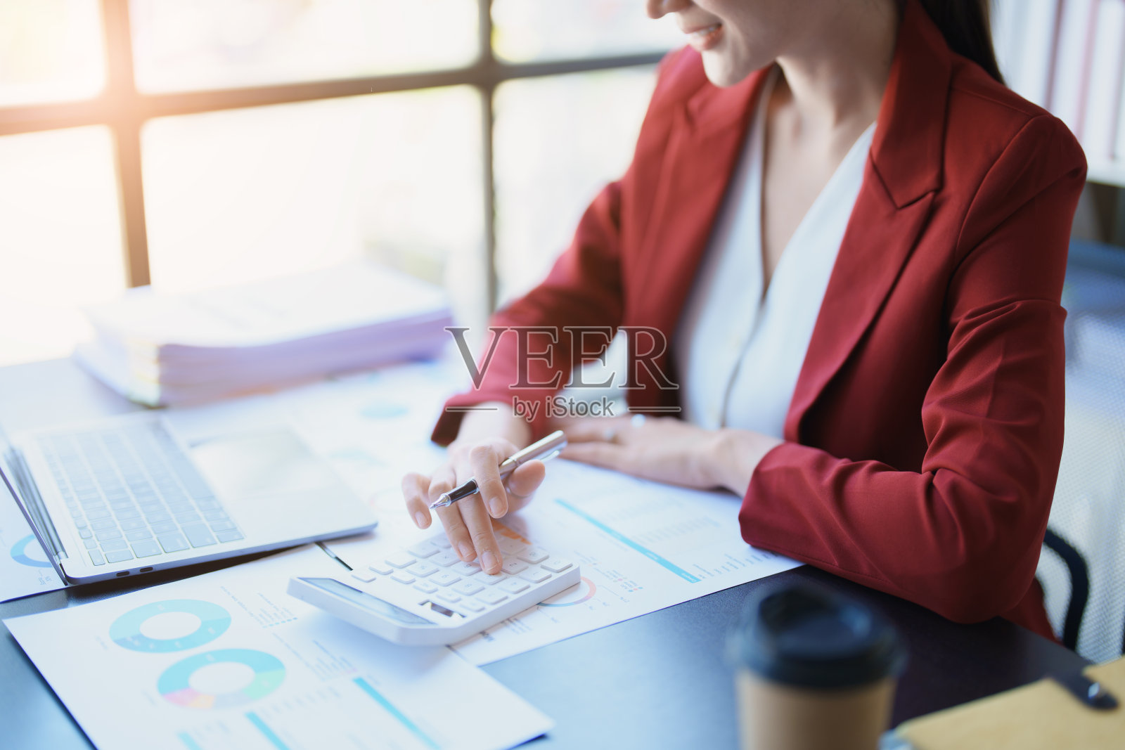 会计师、亚洲审计员正在使用计算器和电脑审查年度税收预算，以便向国税局提交信息。照片摄影图片