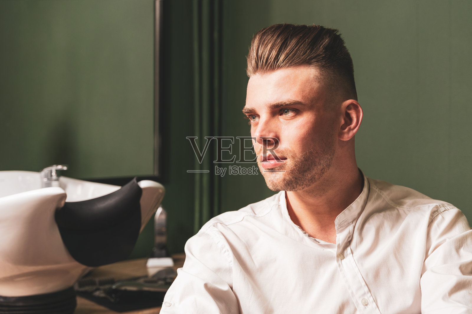 一个年轻的未剃须男子的肖像与美丽的发型照片摄影图片