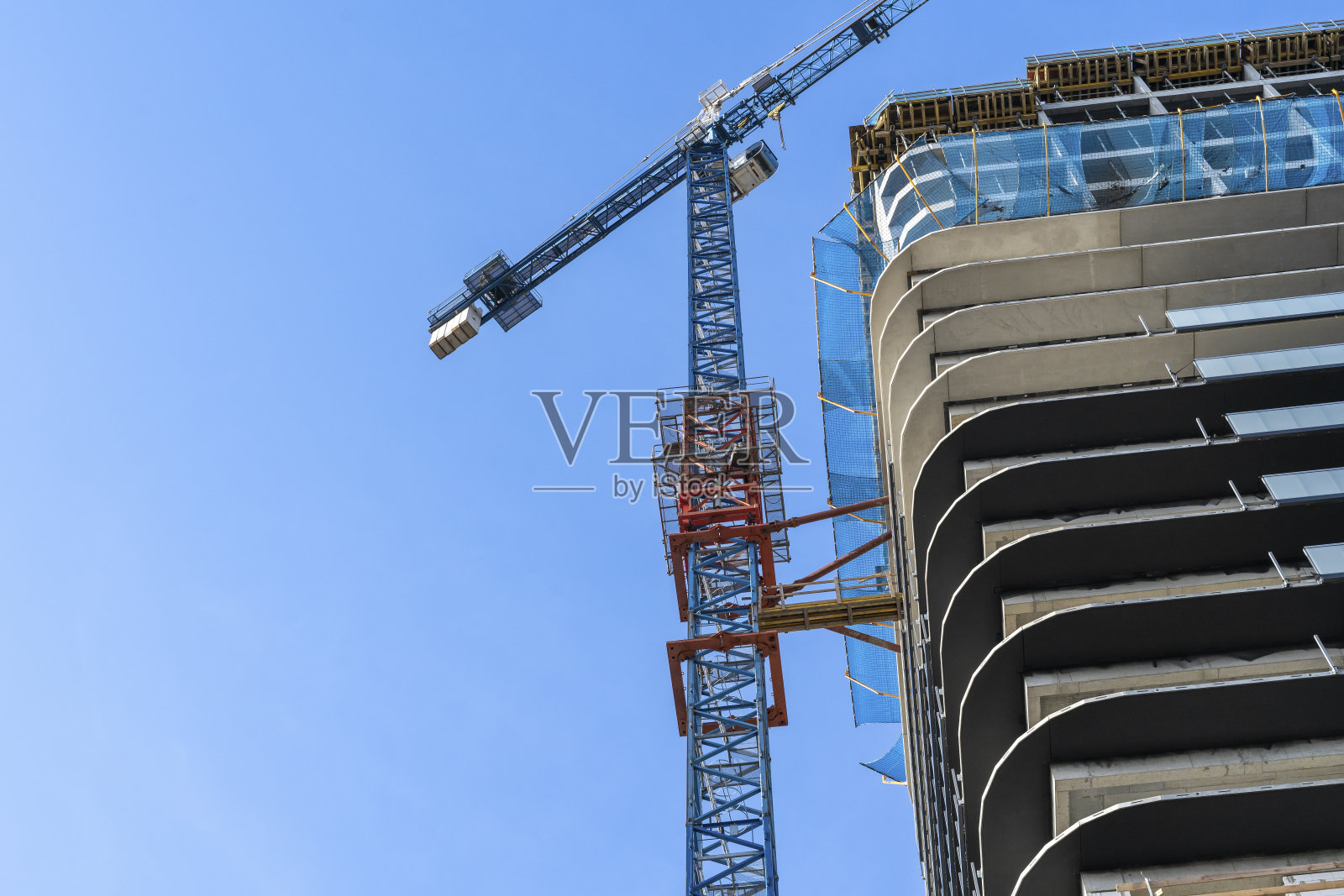 蓝天下的起重机工地。工业背景。现代摩天大楼。未完成的建筑照片摄影图片