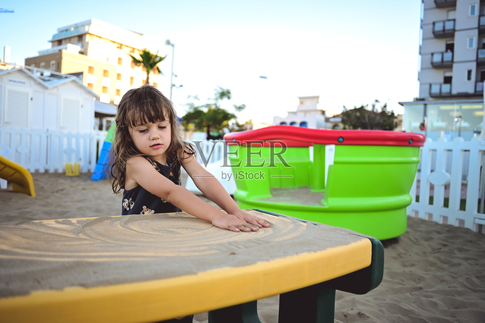 暑假在沙滩上玩沙子的小女孩照片摄影图片