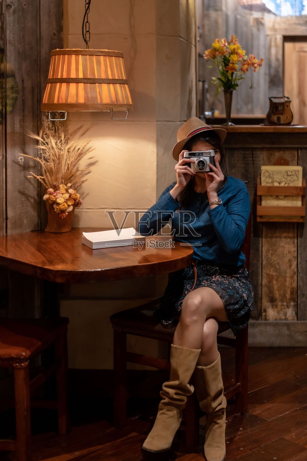 西班牙美女游客带着帽子在咖啡馆里用老式相机拍了一些照片照片摄影图片