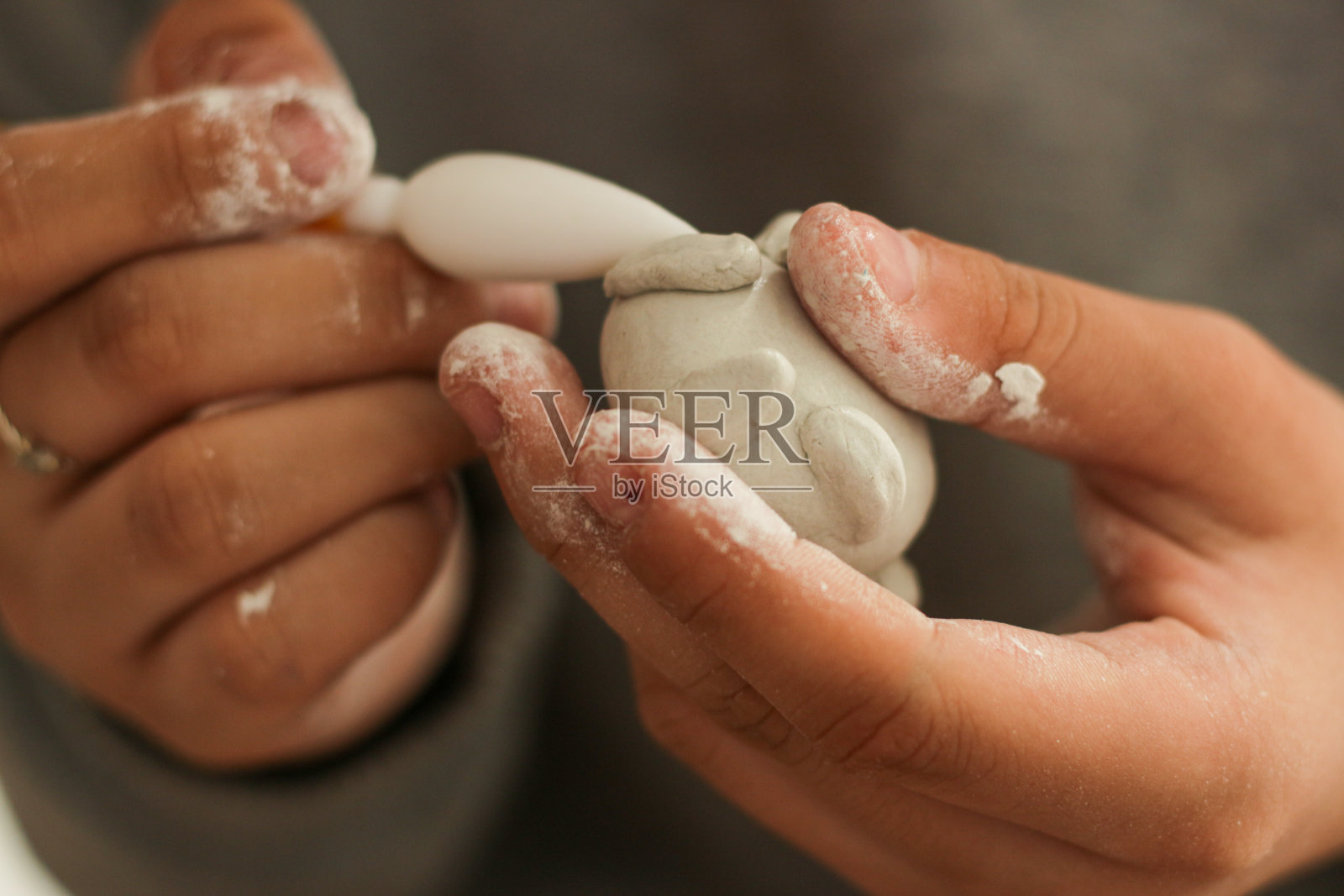 塑造凹痕的女孩将用她的工具，孩子们的创造力，用她自己的双手，制作一个轻盈的橡皮泥雕塑。教育的概念。照片摄影图片